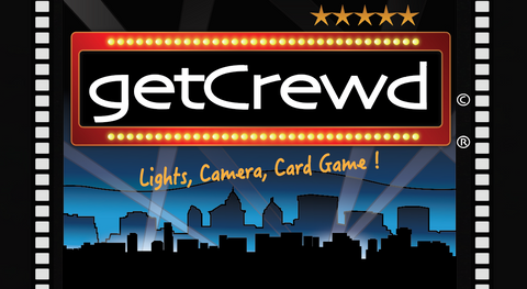 getCrewd Party Card Game lead photo on website showing a city at night with big spotlights and a theater marquee.  LIghts, Camera, Card Game !